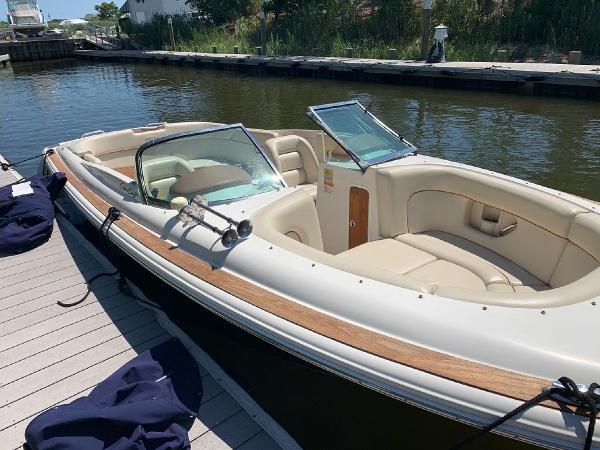 Slide: The Image of 2006 Chris-Craft Launch 25 boat docked, featuring elegant design and spacious seating. - 5