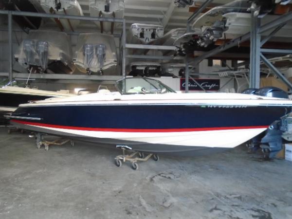 Slide: The Image of 2020 Chris-Craft Launch 27 boat in storage, featuring a sleek navy and white design. - 1