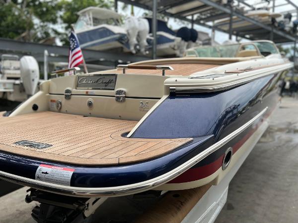Slide: The Image of 2022 Chris-Craft Launch 27 boat with teak deck and American flag in marina. - 11