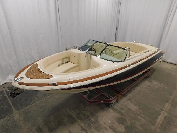 Slide: The Image of 2022 Chris-Craft Launch 27 boat in showroom, elegant design, luxury seating. - 13
