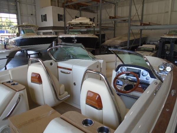 Slide: The Image of 2022 Chris-Craft Launch 27 boat interior in a showroom, featuring elegant seating and dashboard. - 15