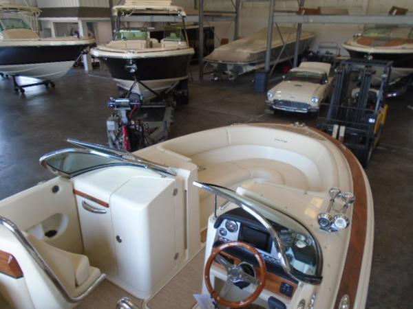 Slide: The Image of 2022 Chris-Craft Launch 27 in a showroom with other boats and vehicles. - 17
