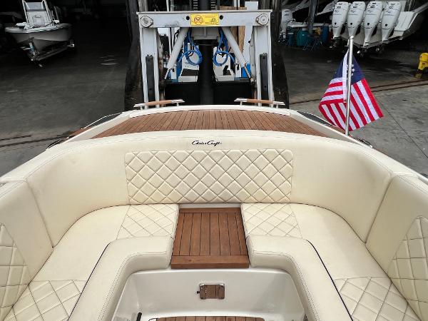 Slide: The Image of 2022 Chris-Craft Launch 27 boat with American flag, docked in a marina. - 21