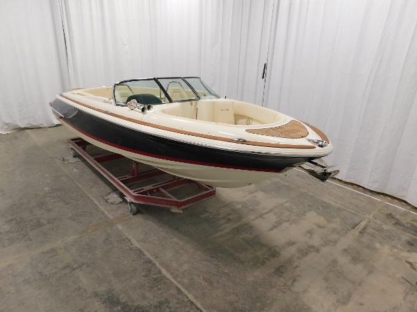 Slide: The Image of 2022 Chris-Craft Launch 27 boat in showroom, black and white exterior, elegant design. - 6