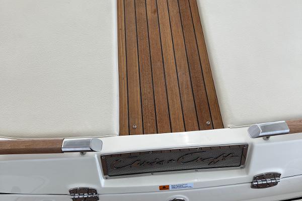 Slide: The Image of 2023 Chris-Craft Launch 27 boat deck with teak wood and white upholstery. - 13