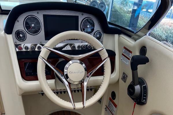 Slide: The Image of 2023 Chris-Craft Launch 27 dashboard with steering wheel and control panel. - 2
