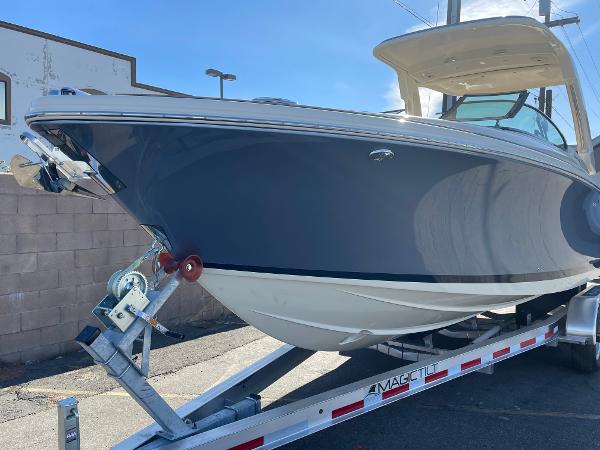 Slide: The Image of 2024 Chris-Craft Launch 28 GT boat on trailer, sleek design, blue hull. - 1