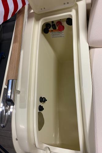 Slide: The Image of 2025 Chris-Craft Launch 28 GT storage compartment with control switches and American flag detail. - 24