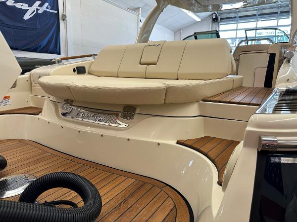 Slide: The Image of 2024 Chris-Craft Launch 31 GT luxury boat interior with beige seating and wooden deck. - 23