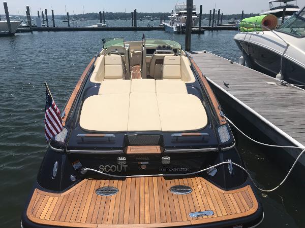 Slide: The Image of 2019 Chris-Craft Launch 34 docked, featuring elegant teak decking and luxurious seating. - 0