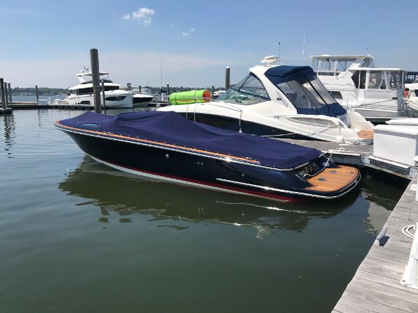 Slide: The Image of 2019 Chris-Craft Launch 34 boat docked with cover, in a marina setting. - 1