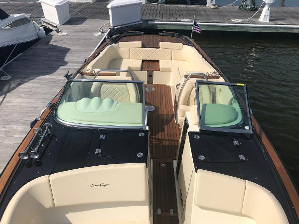 Slide: The Image of 2019 Chris-Craft Launch 34 boat with elegant seating and wooden deck at a marina. - 11