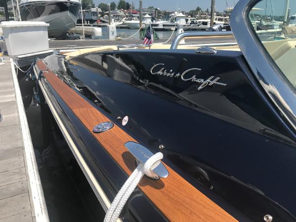 Slide: The Image of 2019 Chris-Craft Launch 34 boat docked, showcasing sleek design and polished wood accents. - 2