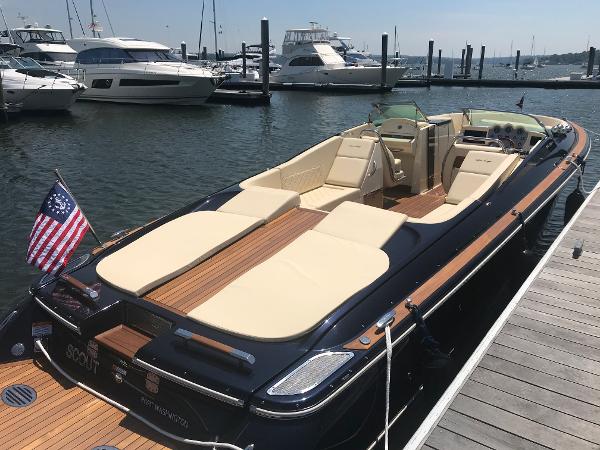 Slide: The Image of 2019 Chris-Craft Launch 34 boat docked at marina, featuring elegant design and spacious seating. - 8