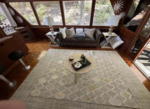 Slide: The Image of 1976 Chris-Craft Roamer interior with cozy seating, large windows, and elegant decor. - 12