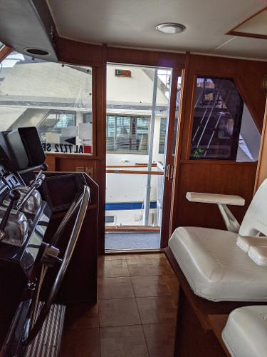 Slide: The Image of 1976 Chris-Craft Roamer yacht interior with helm and seating area. - 37