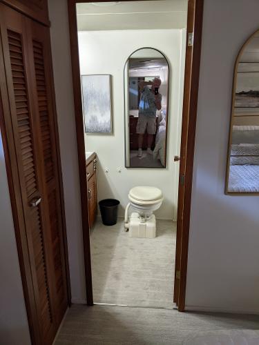 Slide: The Image of 1976 Chris-Craft Roamer bathroom interior with toilet, mirror, and wooden cabinets. - 48