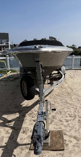 Slide: The Image of 2011 Chris-Craft Silver Bullet 20 boat on a trailer by the waterfront. - 2