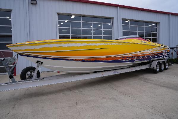 Slide: The Image of 2005 Cigarette 38 Top Gun speedboat on a trailer outside a garage. - 1