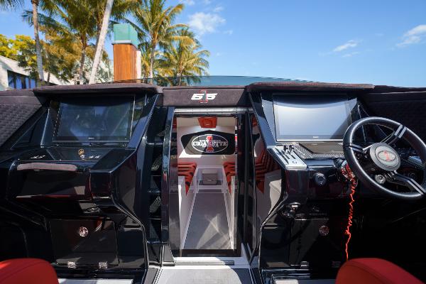 Slide: The Image of 2022 Cigarette 515 boat cockpit with modern controls and steering wheel, surrounded by palm trees. - 4