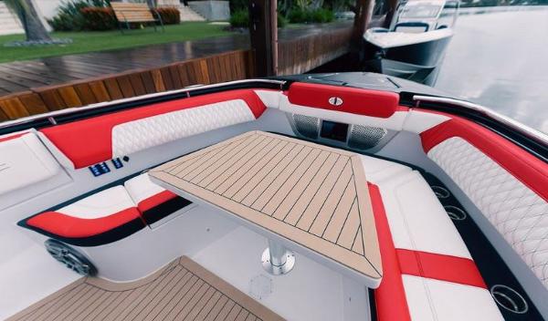 Slide: The Image of 2024 Cigarette 52 Thunder boat interior with red and white seating and a wooden table. - 7