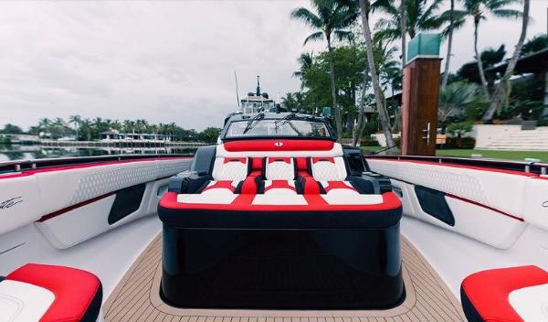 Slide: The Image of 2024 Cigarette 52 Thunder luxury speedboat with red and white seating, docked near palm trees. - 8
