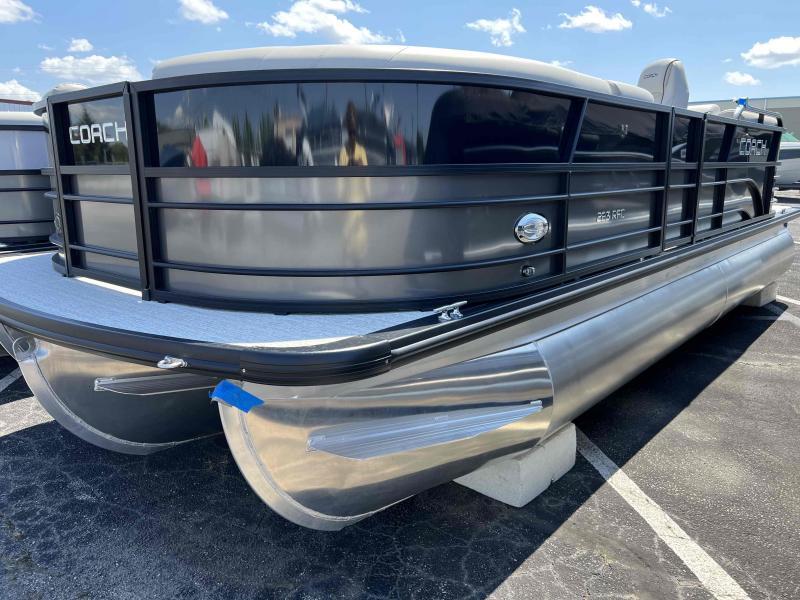 Slide: The Image of 2023 Coach 223 RFC pontoon boat in a parking lot under a clear sky. - 1