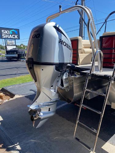 Slide: The Image of 2023 Coach Pontoons 223RFC with Honda outboard motor and ladder, parked near Ski Shack. - 11