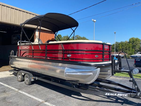 Slide: The Image of 2023 Coach Pontoons 223RFC on trailer, red exterior, parked outdoors. - 2