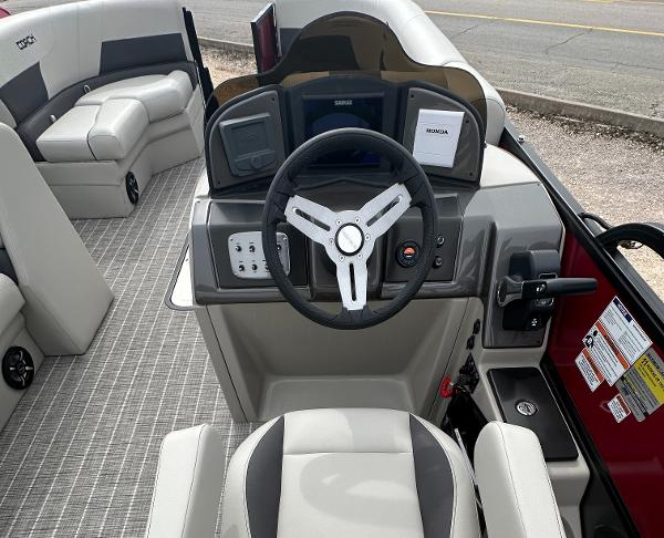 Slide: The Image of 2023 Coach Pontoons 243PFC boat interior with steering wheel and seating. - 4