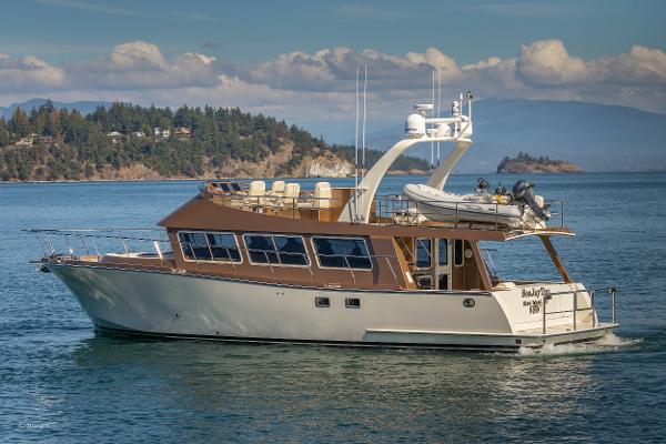 Slide: The Image of 2012 Coastal Craft 56 yacht cruising on scenic waters with islands in the background. - 1