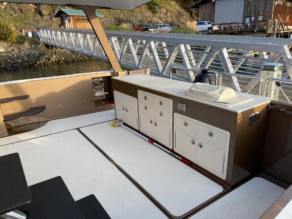 Slide: The Image of Outdoor deck of a 2012 Coastal Craft 56 yacht with storage cabinets and scenic marina view. - 15