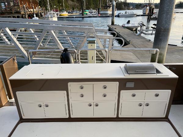 Slide: The Image of Outdoor kitchen on a 2012 Coastal Craft 56 yacht, docked at a marina. - 16