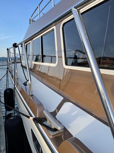 Slide: The Image of 2012 Coastal Craft 56 yacht docked, showcasing sleek design and reflective windows. - 17