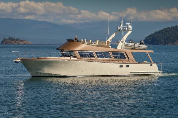 Slide: The Image of Luxury 2012 Coastal Craft 56 yacht cruising on serene waters with scenic mountain backdrop. - 2