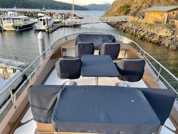 Slide: The Image of Luxury 2012 Coastal Craft 56 yacht with cushioned seating, docked at a scenic marina. - 22