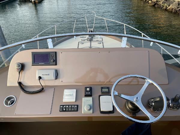 Slide: The Image of Helm of 2012 Coastal Craft 56 yacht with steering wheel and navigation controls. - 24