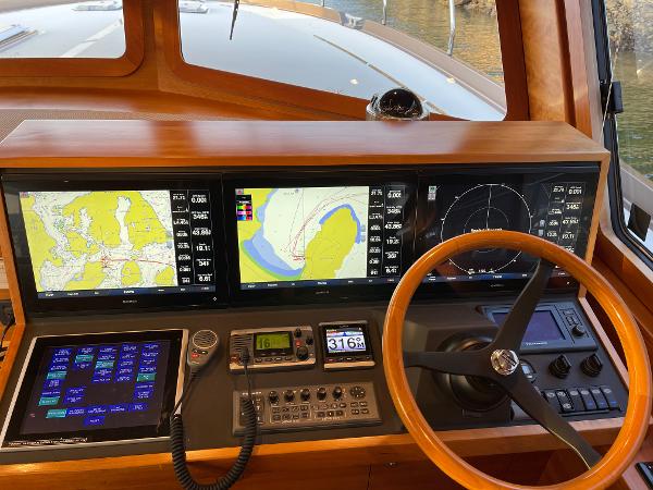 Slide: The Image of Coastal Craft 56 yacht helm with navigation screens and wooden steering wheel, 2012 model. - 29