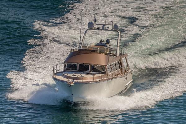 Slide: The Image of 2012 Coastal Craft 56 yacht cruising on open water, leaving a foamy wake. - 3