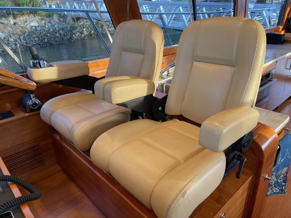 Slide: The Image of Luxurious beige seats inside a 2012 Coastal Craft 56 yacht, with wooden interior accents. - 30