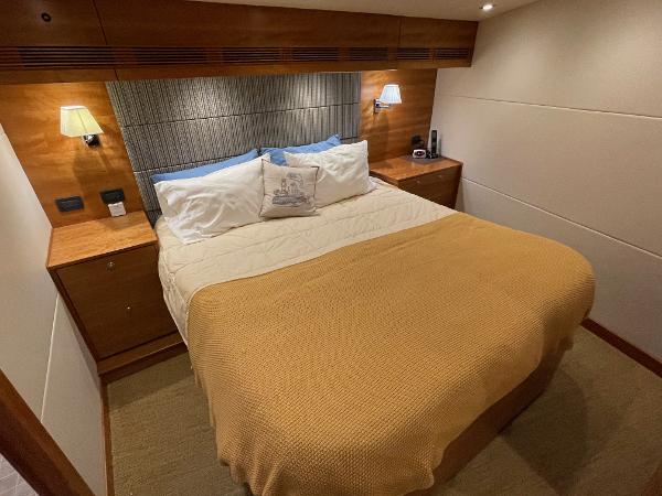 Slide: The Image of Luxurious bedroom in a 2012 Coastal Craft 56 yacht, featuring elegant wood paneling and cozy lighting. - 38