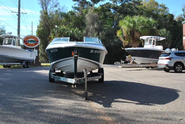 Slide: The Image of 1998 Cobalt 200 boat on trailer in parking lot with trees and other boats. - 18