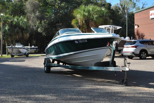 Slide: The Image of 1998 Cobalt 200 boat on trailer in parking lot with trees and cars. - 19