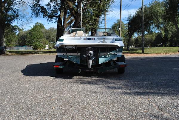 Slide: The Image of 1998 Cobalt 200 boat on trailer, parked on a sunny road with trees. - 24