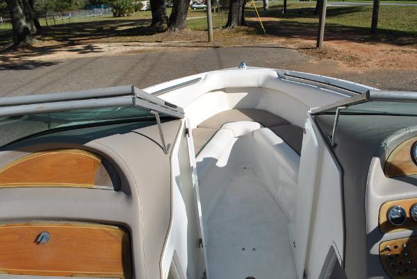 Slide: The Image of 1998 Cobalt 200 boat interior with beige seating and wooden accents, parked on a road. - 26