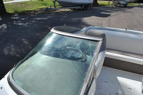 Slide: The Image of 1998 Cobalt 200 boat with cracked windshield, parked on pavement. - 29