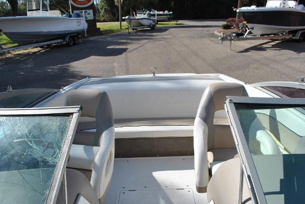 Slide: The Image of 1998 Cobalt 200 boat interior with seating and cracked windshield, parked near other boats. - 30