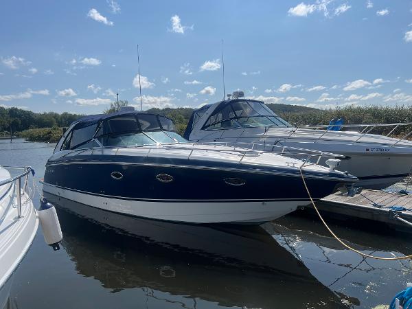 Slide: The Image of 2003 Cobalt 360 boat docked at a marina on a sunny day. - 0