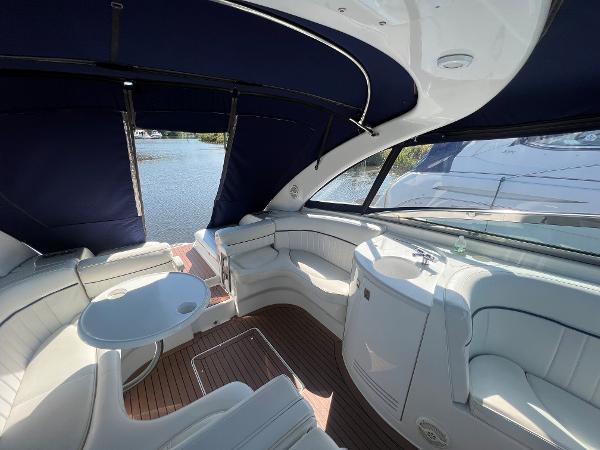 Slide: The Image of Interior of 2003 Cobalt 360 boat with white seating and blue canopy. - 16