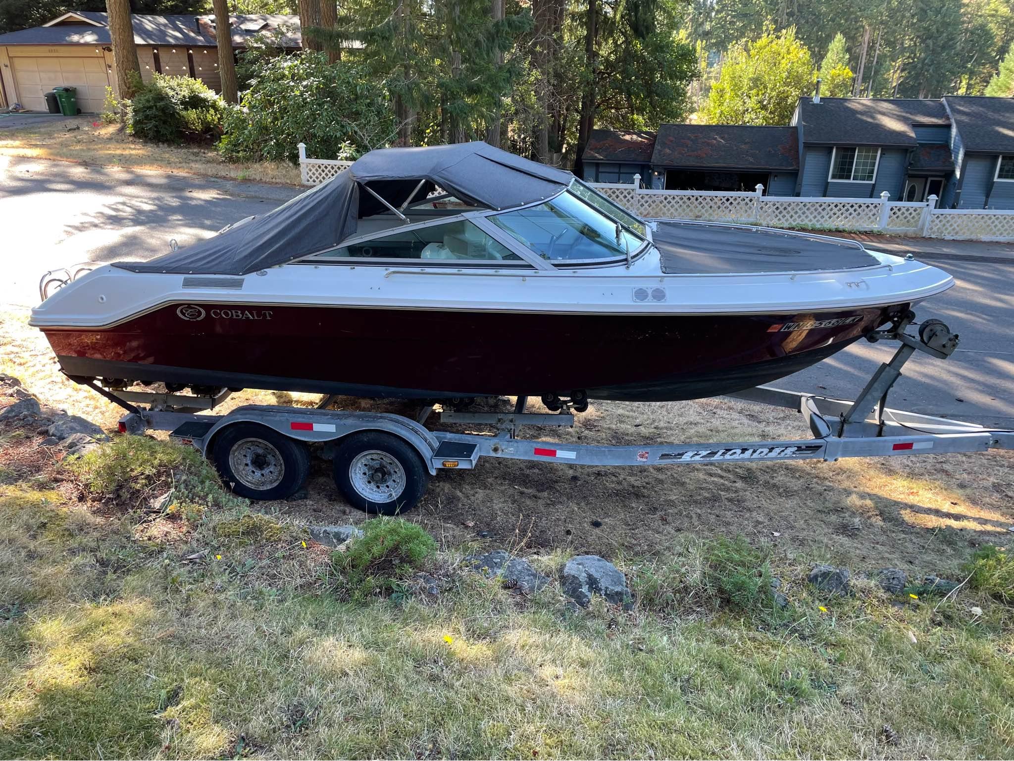 Slide: The Image of 1989 Cobalt CONDURRE boat on trailer, parked in a residential area. - 0